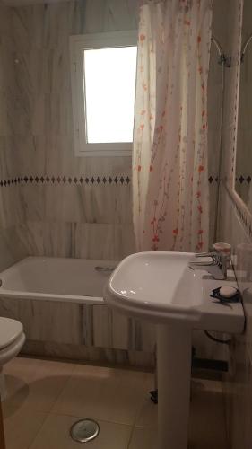 Baño blanco con bañera y lavamanos en Los olivos apartamento, en Vera