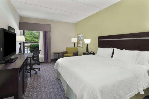 a hotel room with a bed and a desk and a television at Hampton Inn Atlanta-Town Center/Kennesaw in Kennesaw