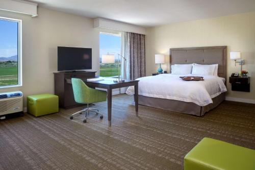 布萊斯的住宿－加利福尼亞州布萊斯漢普頓酒店及套房，酒店客房配有一张床、一张书桌和一台电视。