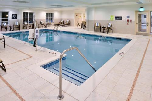 a pool in a hotel room with tables and chairs at Homewood Suites by Hilton Columbia/Laurel in Laurel