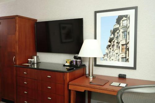 Habitación de hotel con escritorio con lámpara y TV. en DoubleTree by Hilton Boston/Westborough en Westborough