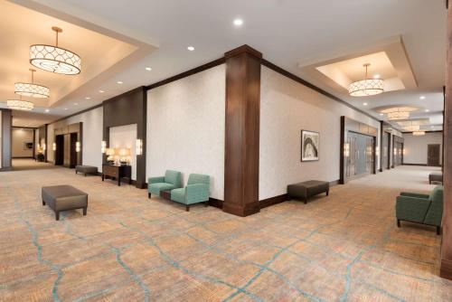 a lobby with couches and chairs in a building at Embassy Suites by Hilton Chicago Naperville in Naperville