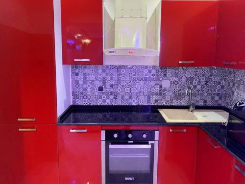 a red kitchen with a stove and a sink at Residence Patricia in Cotonou