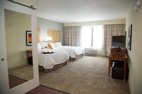 a hotel room with two beds and a television at Hampton Inn and Suites by Hilton McKinney in McKinney