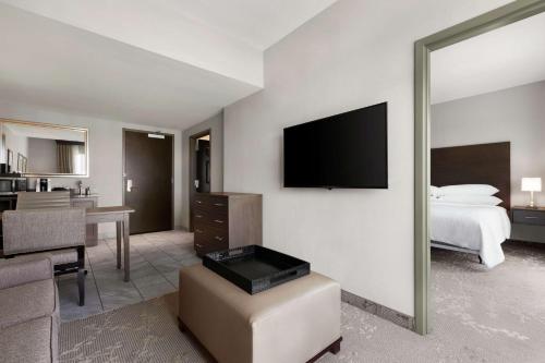 a hotel room with a bed and a mirror at Embassy Suites Charlotte/Ayrsley in Charlotte