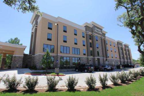 a building with cars parked in a parking lot at Hampton Inn & Suites Dallas Market Center in Dallas