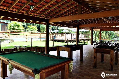 a pool table on a patio with awning at Eco Chalés Luar das Marés in Ubatuba