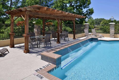 a pool with a gazebo and a table and chairs at Hampton Inn & Suites Dallas Market Center in Dallas