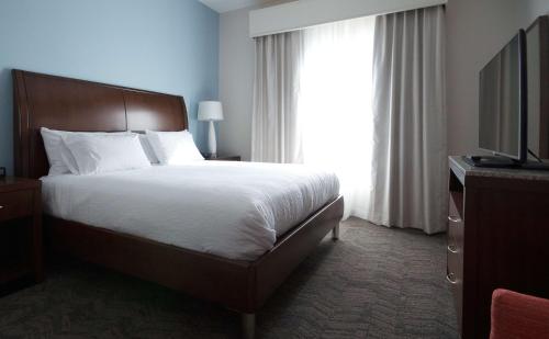 a bedroom with a large bed and a window at Hilton Garden Inn Hickory in Hickory