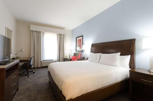 a hotel room with a large bed and a desk at Hilton Garden Inn Hickory in Hickory