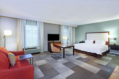 ヒューストンにあるHampton Inn & Suites Houston North IAH, TXのベッドとデスクが備わるホテルルームです。