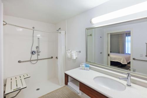 Baño blanco con lavabo y espejo en Hampton Inn & Suites Houston North IAH, TX, en Houston