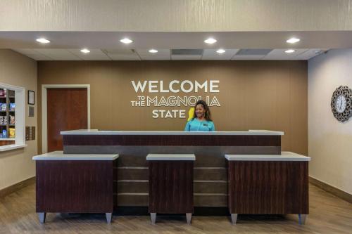 a woman standing at a welcome counter in a waiting room at Hampton Inn and Suites Columbus, MS in Columbus