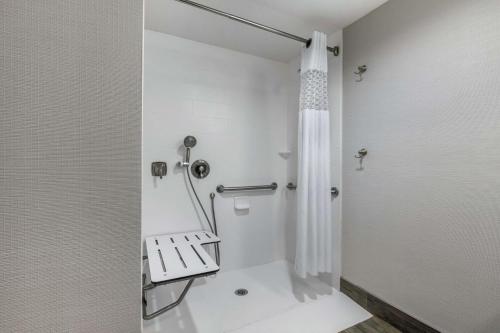 y baño con ducha y banco. en Hampton Inn and Suites Columbus, MS, en Columbus