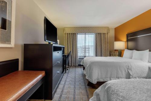 a hotel room with two beds and a flat screen tv at Hampton Inn and Suites Columbus, MS in Columbus
