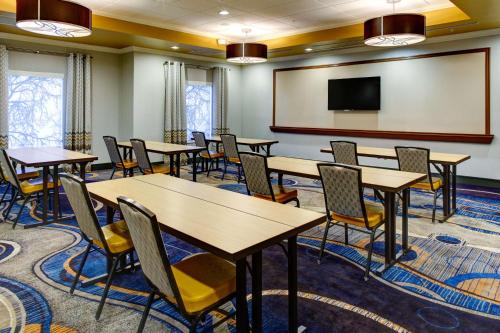 a conference room with tables and chairs and a screen at Hampton Inn and Suites Columbus, MS in Columbus