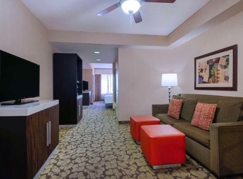 a living room with a couch and a flat screen tv at Hilton Garden Inn Las Vegas Strip South in Las Vegas