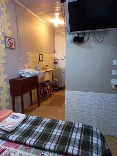 Habitación con cama y TV en la pared. en Habitación Independiente, en Chuy