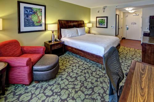 Hilton Garden Inn Memphis/Wolfchase Galleria في ممفيس: غرفه فندقيه بسرير وكرسي