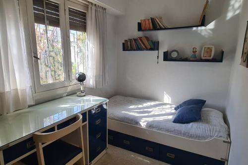 Habitación pequeña con cama y escritorio con ventana. en Casa 5 personas. Calle principal Cañuelas en Cañuelas