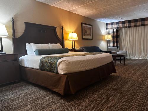 a hotel room with a large bed and a chair at Red Lion Hotel Harrisburg Hershey in Harrisburg