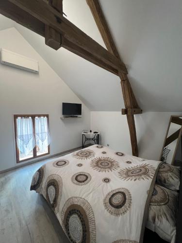 a bedroom with a large bed in a attic at la vallées du tuffeau in Bourré