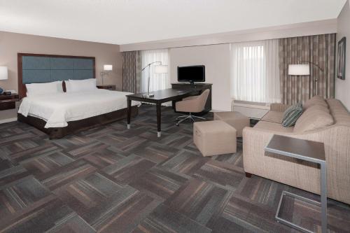 ein Hotelzimmer mit einem Bett und einem Schreibtisch in der Unterkunft Hampton Inn & Suites Munster in Munster