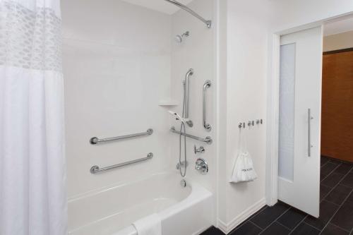 uma casa de banho branca com uma banheira e um chuveiro em Hampton Inn & Suites Munster em Munster