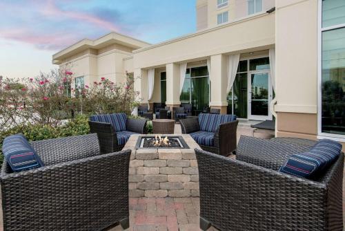 a patio with wicker chairs and a fire pit at Hilton Garden Inn San Antonio/Rim Pass Drive in San Antonio