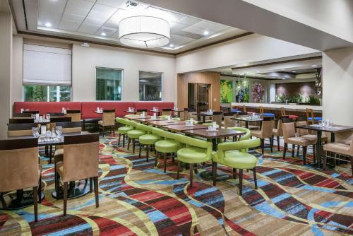 a dining room with tables and chairs on a colorful rug at Hilton Garden Inn San Antonio/Rim Pass Drive in San Antonio