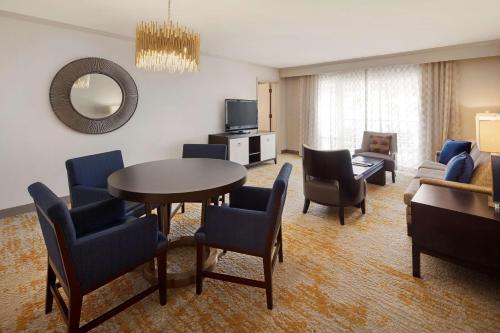 a living room with a table and chairs and a couch at DoubleTree by Hilton Ontario Airport in Ontario