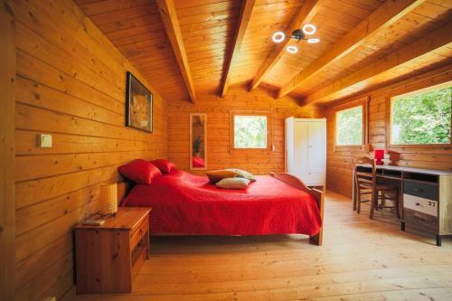 a bedroom with a red bed in a wooden cabin at Maison du Riou, meublé de tourisme 3 etoiles vue sur colline avec piscine in Roquevaire