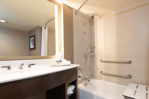a bathroom with a sink and a shower and a tub at DoubleTree by Hilton Schenectady in Schenectady