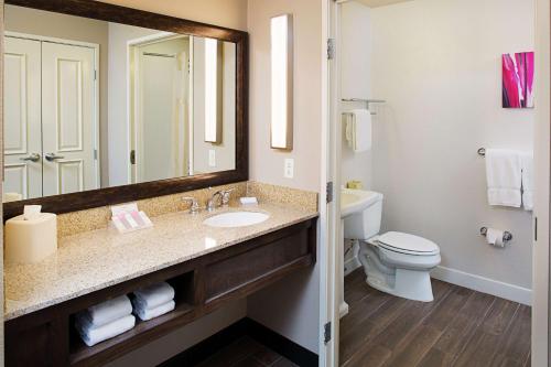 uma casa de banho com um lavatório, um WC e um espelho. em Hilton Garden Inn San Luis Obispo/Pismo Beach em Pismo Beach