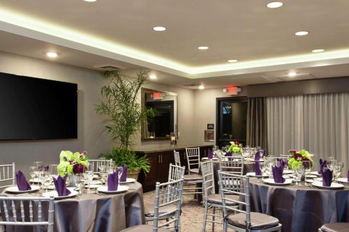 a conference room with tables and chairs and a screen at Hilton Garden Inn Irvine/Orange County Airport in Irvine