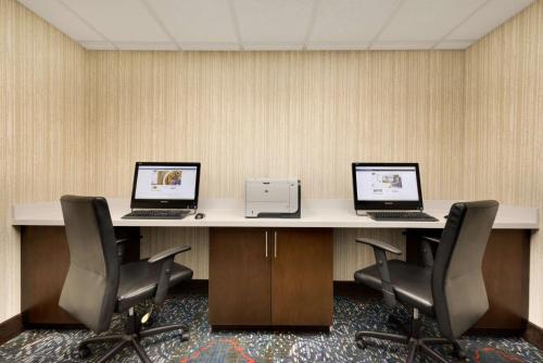 two computers sitting on a table with chairs at Hampton Inn and Suites Monroe in Monroe
