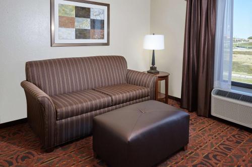 a living room with a couch and a ottoman in a hotel room at Hampton Inn & Suites Milwaukee/Franklin in Franklin