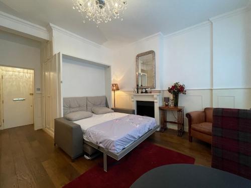 ein Schlafzimmer mit einem Bett, einem Sofa und einem Spiegel in der Unterkunft Jefferson House in London