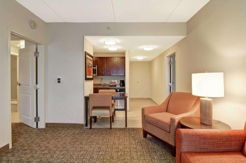 a living room with a couch and chairs and a table at Homewood Suites by Hilton Woodbridge in Woodbridge