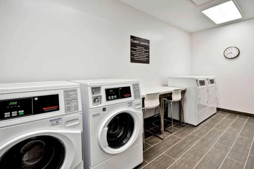 a laundry room with two washing machines and a table at Homewood Suites by Hilton Cincinnati/West Chester in West Chester