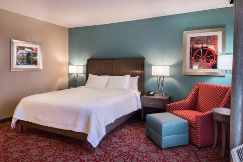 a hotel room with a bed and a chair at Hilton Garden Inn Bristol in Bristol