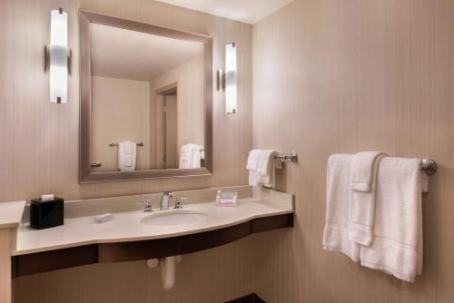a bathroom with a sink and a mirror and towels at Hilton Garden Inn Bristol in Bristol