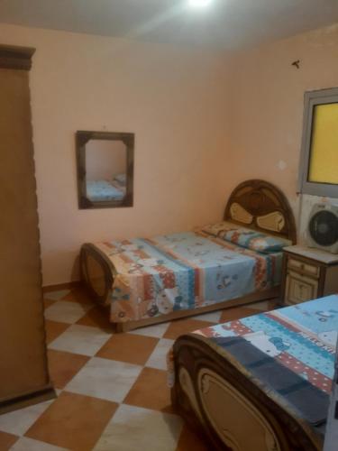 1 dormitorio con 2 camas y espejo en شقة مميزة فى الاسكندرية قرية الزهراء Alexandria, en Alejandría