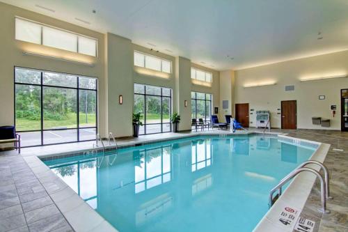 a large swimming pool in a building with windows at Homewood Suites By Hilton Clifton Park in Clifton Park