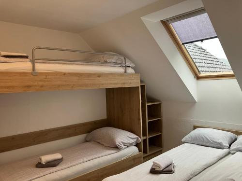 2 Etagenbetten in einem Zimmer mit Fenster in der Unterkunft Apartment Ozebek in Cerkno