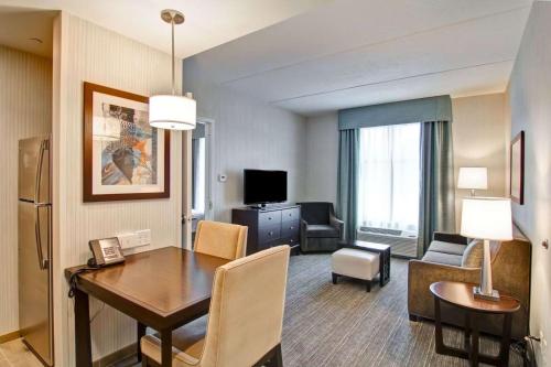 a living room with a dining room table and a room with a living room at Homewood Suites By Hilton Clifton Park in Clifton Park