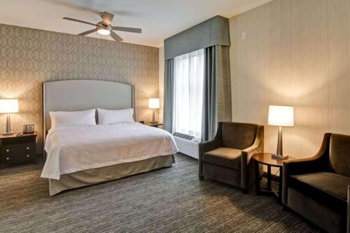 a hotel room with a bed and a chair at Homewood Suites By Hilton Clifton Park in Clifton Park