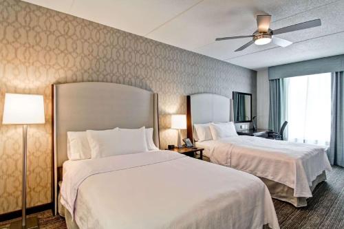 a hotel room with two beds and a ceiling fan at Homewood Suites By Hilton Clifton Park in Clifton Park