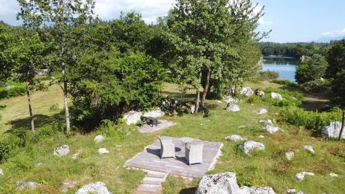a picnic table in the grass next to a lake at River House Moon in Gospić