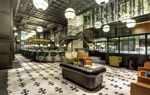 a lobby with a leather couch and a bar at Hilton Norfolk The Main in Norfolk